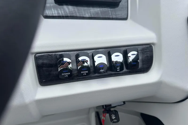 Slide: The Image of Control panel of 2025 Tahoe 2185 with labeled switches for lights and radio. - 23