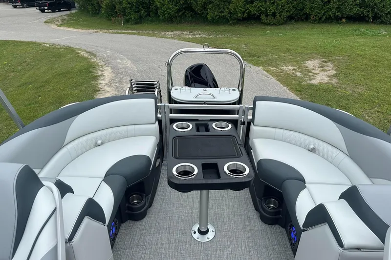 Slide: The Image of 2025 Tahoe 2185 boat interior with plush seating and cup holders on a sunny day. - 25