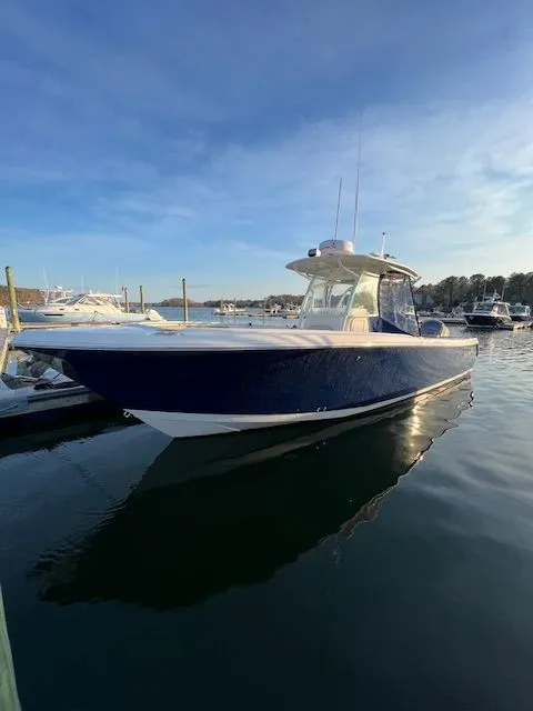 The Image of 2018 Sailfish 320 CC boat on stands, blue sky. - 0