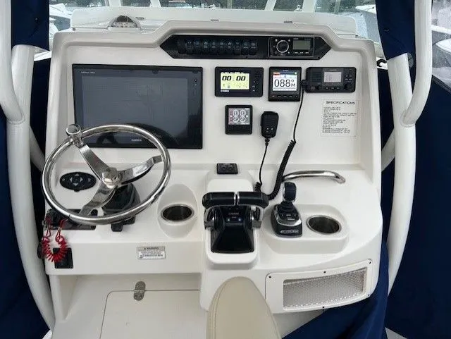 Slide: The Image of 2018 Sailfish 320 CC boat docked with blue cover. - 2