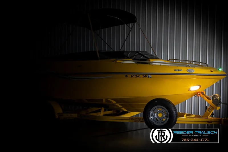 Slide: The Image of 2007 Crownline 21 SS boat in a dimly lit garage, showcasing its sleek yellow design. - 4