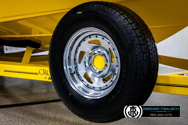 Slide: The Image of Close-up of a 2007 Crownline 21 SS trailer wheel with chrome rim and yellow accents. - 54