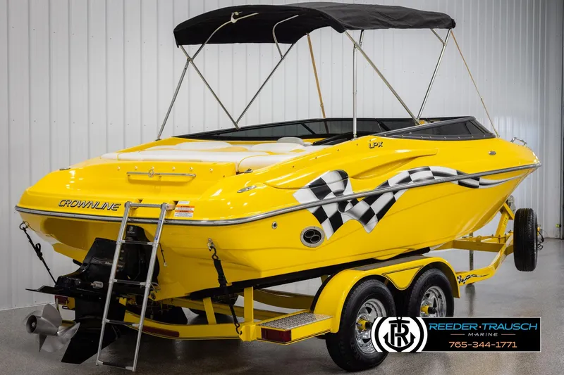 Slide: The Image of Yellow 2007 Crownline 21 SS boat with checkered flag design on trailer in showroom. - 6