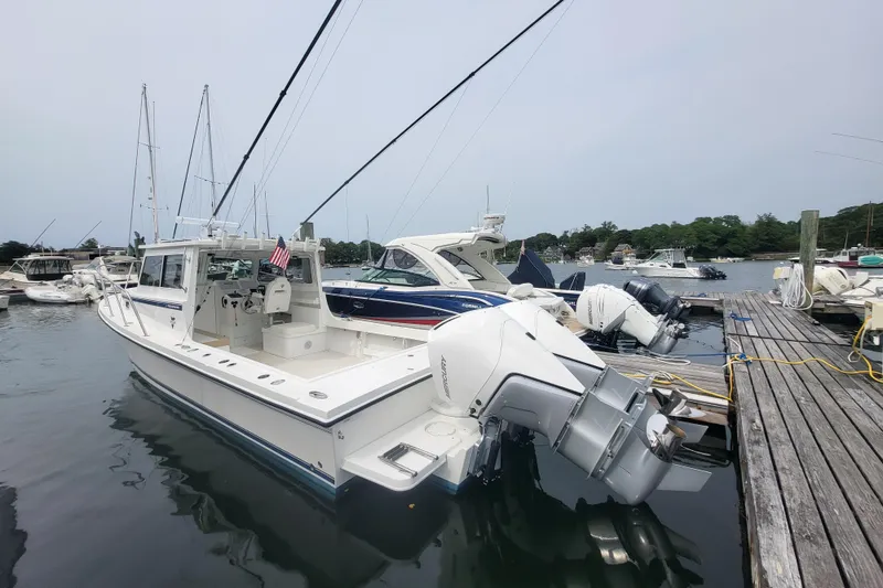 Slide: The Image of 2023 Steiger Craft 31 Fisherman docked at marina, featuring dual outboard engines. - 1