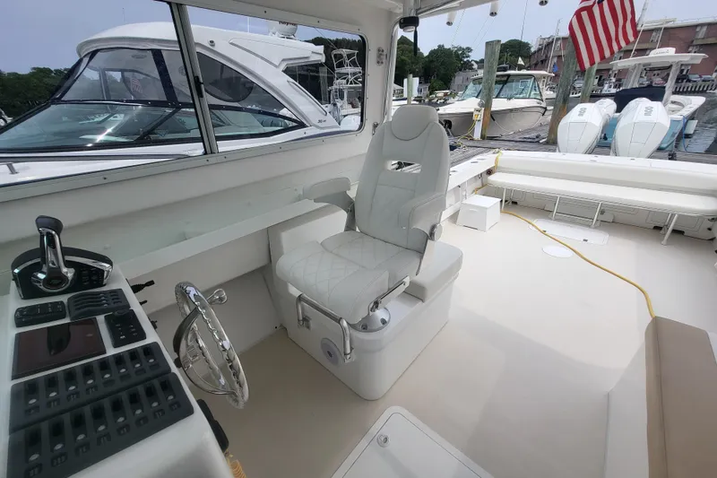 Slide: The Image of 2023 Steiger Craft 31 Fisherman boat interior with helm, seating, and docked view. - 7