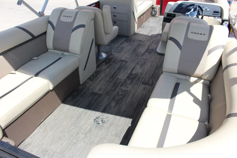 Slide: The Image of 2023 Crest 220 SLS Classic boat interior with beige seating and wood-style flooring. - 6