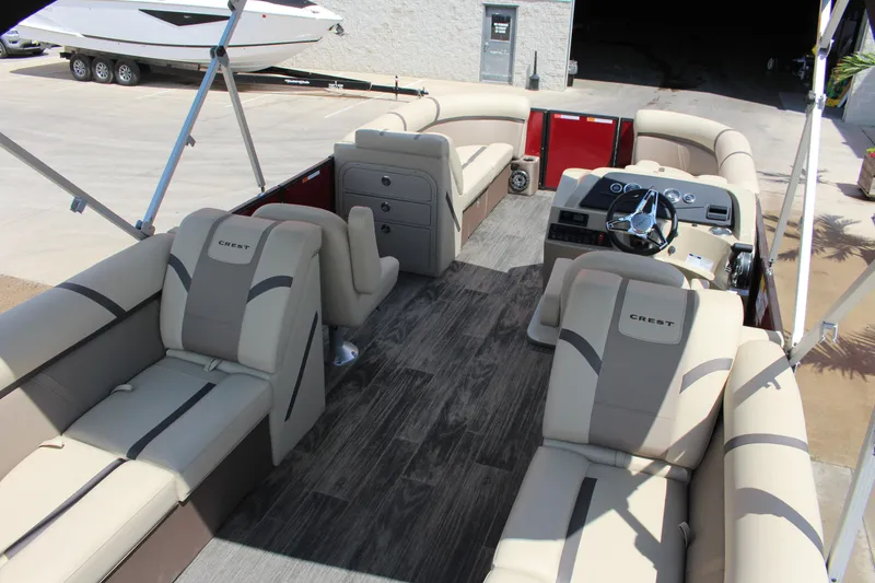 Slide: The Image of 2023 Crest 220 SLS Classic pontoon boat interior with luxurious seating and modern dashboard. - 7