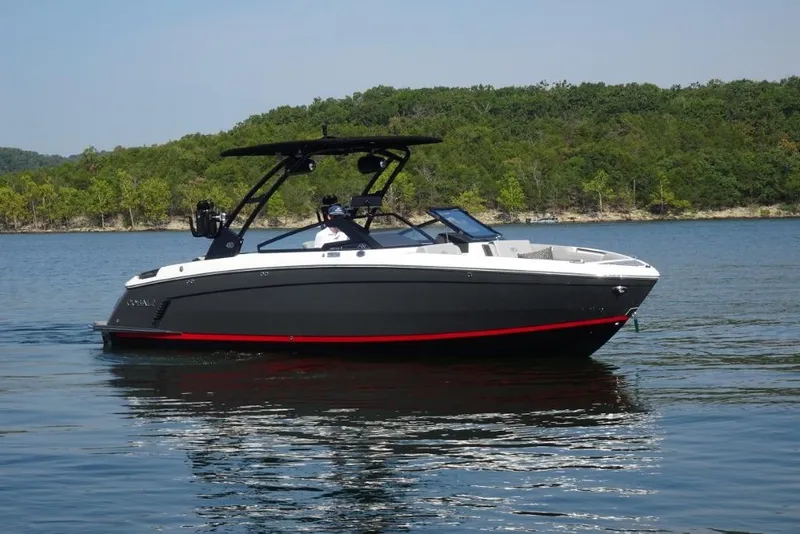 The Image of 2026 Cobalt R8 Surf boat on a serene lake with lush green shoreline. - 0