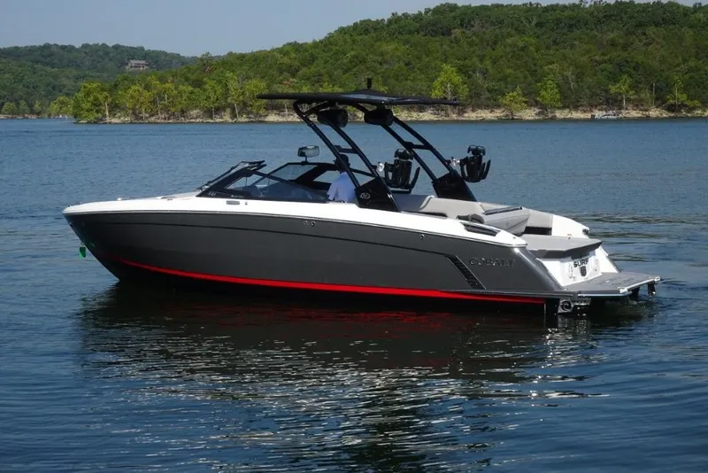 Slide: The Image of 2026 Cobalt R8 Surf boat on a serene lake with lush green shoreline. - 3