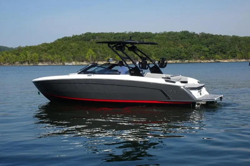 Slide: The Image of 2026 Cobalt R8 Surf boat on a serene lake with forested background. - 4