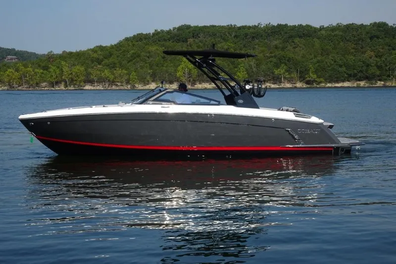 Slide: The Image of 2026 Cobalt R8 Surf boat on a serene lake with lush green shoreline. - 5