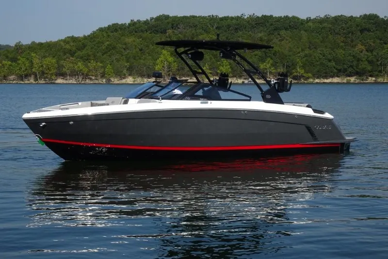 Slide: The Image of 2026 Cobalt R8 Surf boat on a serene lake with lush green shoreline. - 6