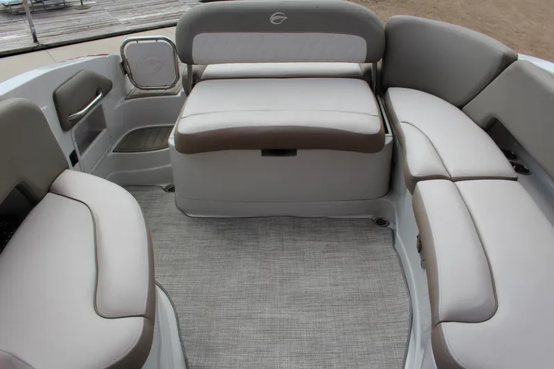 Slide: The Image of 2023 Crownline 290 SS boat interior with beige seating and carpeted floor. - 11
