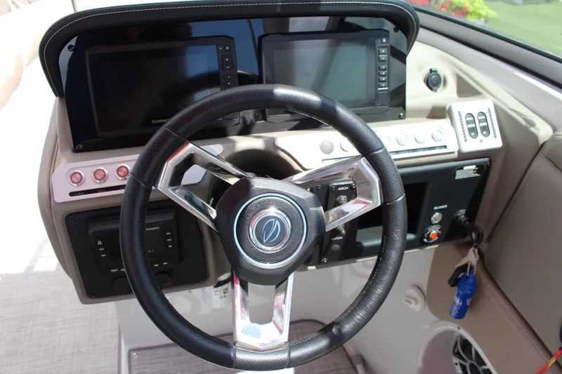 Slide: The Image of 2023 Crownline 290 SS boat dashboard with steering wheel and navigation screens. - 3