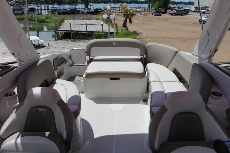 Slide: The Image of 2023 Crownline 290 SS boat interior with luxurious seating and scenic marina view. - 6