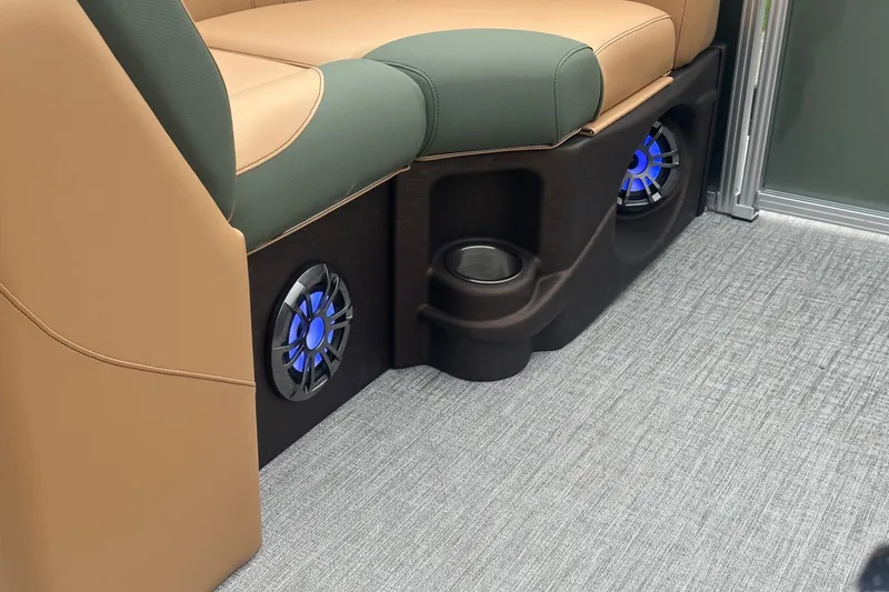 Slide: The Image of 2025 Tahoe 2185 interior with beige and green seating, blue-lit speakers, and cup holder. - 13