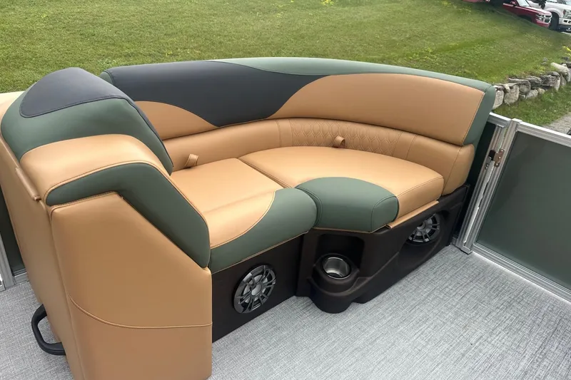Slide: The Image of Luxurious seating on 2025 Tahoe 2185 boat, featuring tan and green upholstery with integrated speakers. - 26