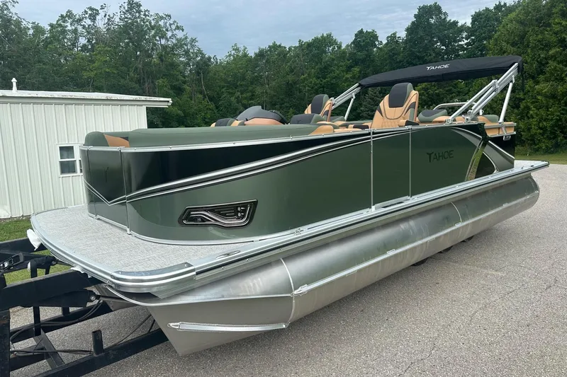Slide: The Image of 2025 Tahoe 2185 pontoon boat with sleek design, parked outdoors. - 3