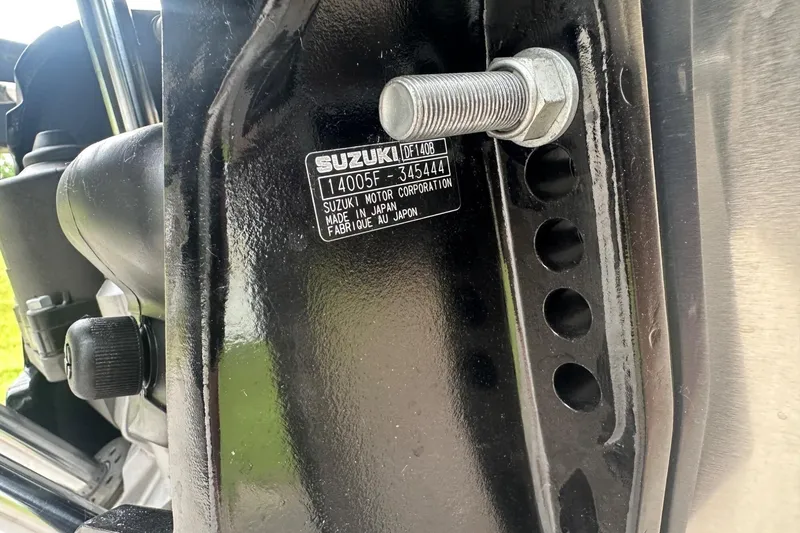 Slide: The Image of Close-up of a Suzuki motor component with label, featuring bolts and metal parts. - 31