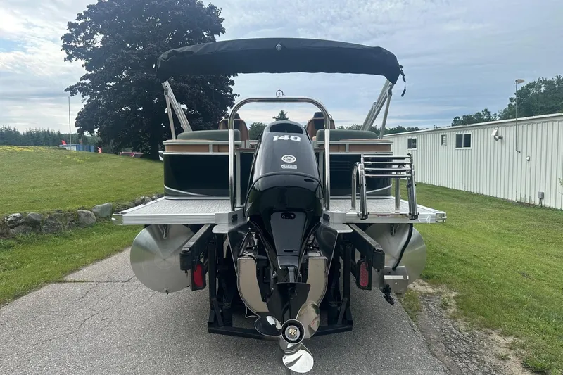 Slide: The Image of 2025 Tahoe 2185 pontoon boat with 140 HP engine, parked on a paved path. - 5