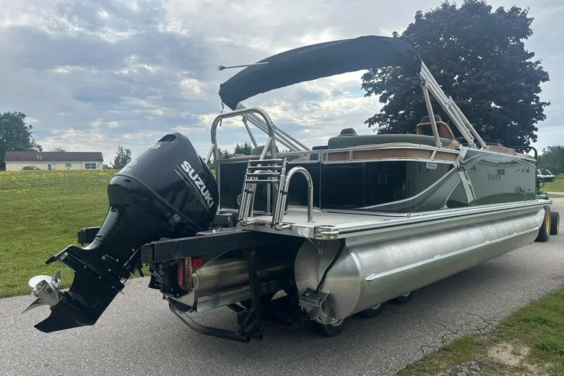 Slide: The Image of 2025 Tahoe 2185 pontoon boat with Suzuki outboard motor on a road. - 6