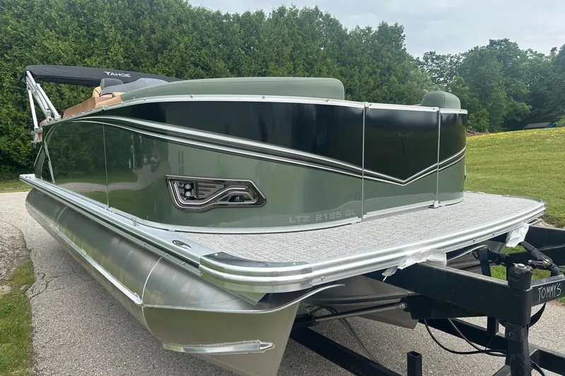 Slide: The Image of 2025 Tahoe 2185 pontoon boat on trailer, green and black design, parked outdoors. - 8