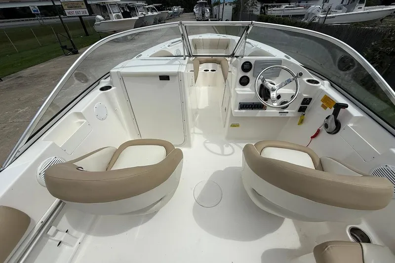 Slide: The Image of 2019 Key West 203 DFS boat interior with beige seating and steering console. - 10