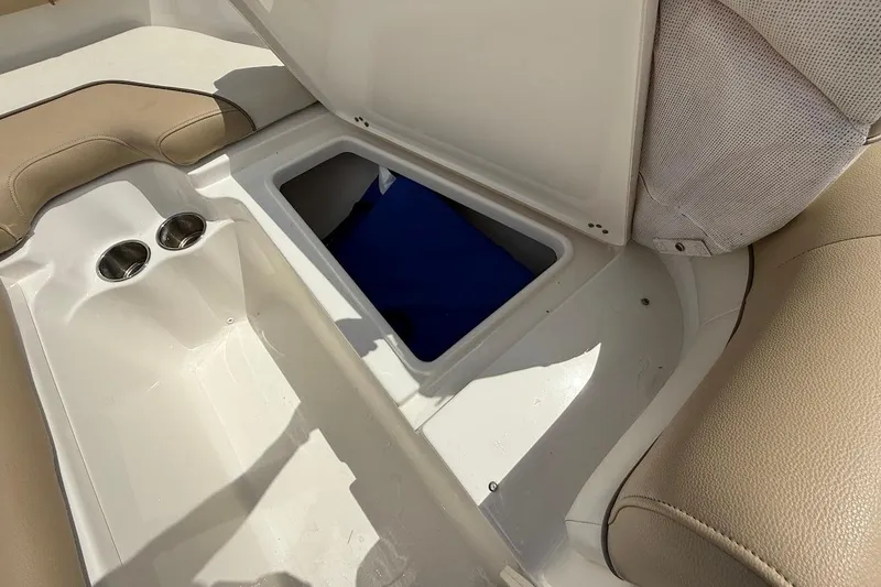 Slide: The Image of 2019 Key West 203 DFS boat interior with open storage compartment and cup holders. - 16