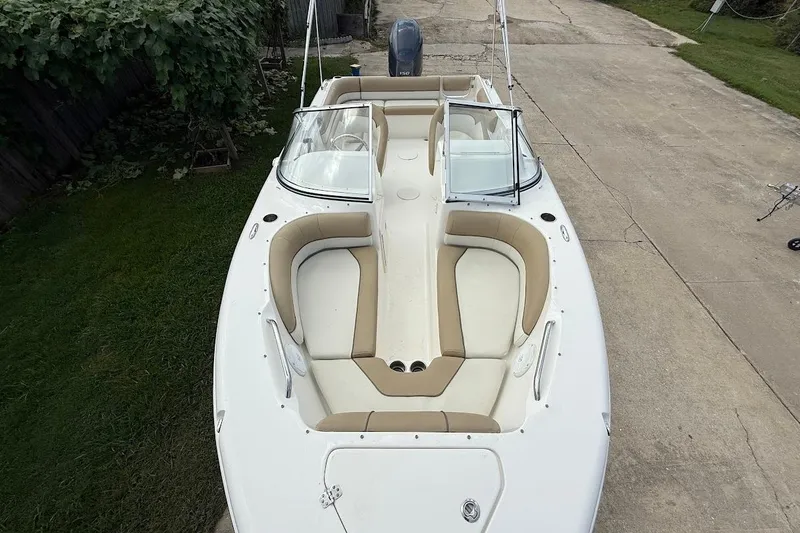 Slide: The Image of 2019 Key West 203 DFS boat with beige seating, parked on concrete driveway. - 19