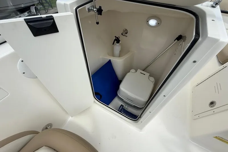 Slide: The Image of 2019 Key West 203 DFS boat interior with storage compartment and portable toilet. - 21