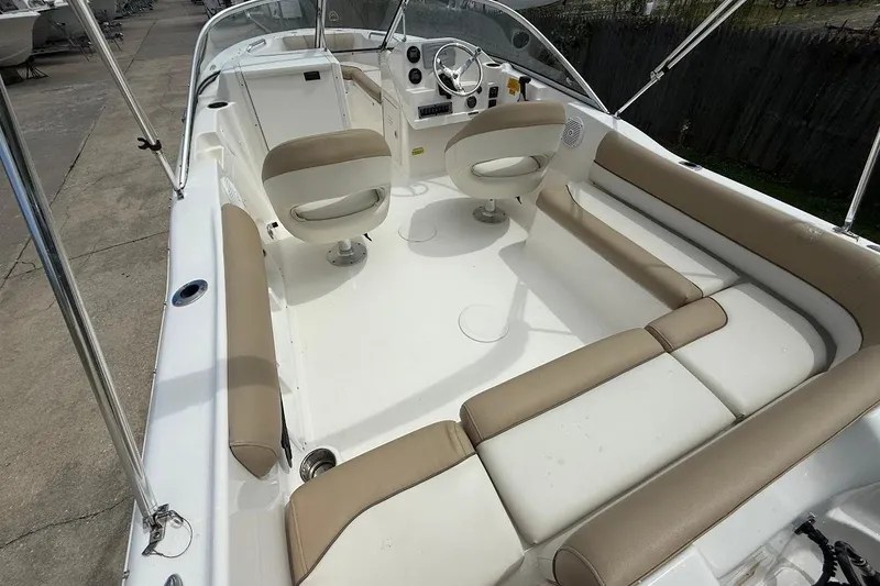 Slide: The Image of 2019 Key West 203 DFS boat interior with beige seating and steering console. - 6