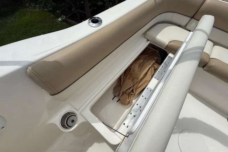 Slide: The Image of 2019 Key West 203 DFS boat interior with storage compartment and beige seating. - 9