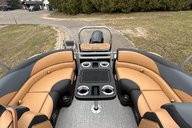 Slide: The Image of 2025 Tahoe 2185 boat interior with tan and black seating, cup holders, and table. - 12