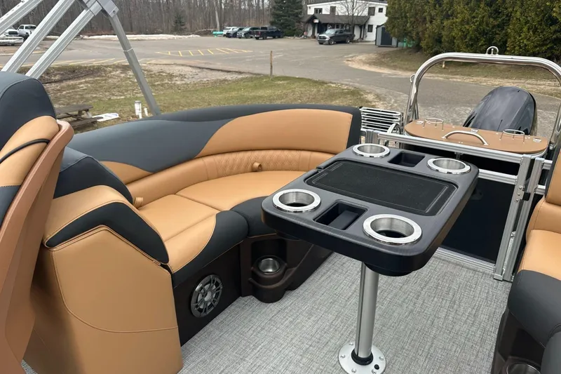 Slide: The Image of Luxurious 2025 Tahoe 2185 boat interior with tan seating and a central table featuring cup holders. - 13