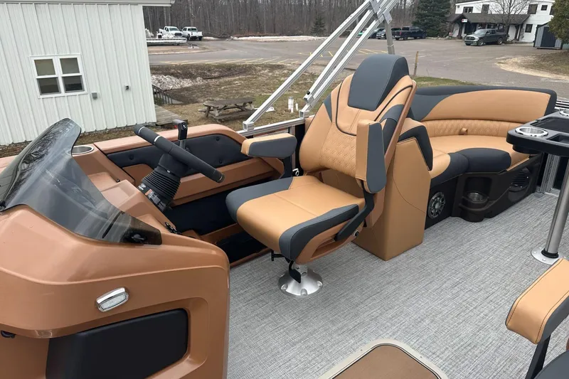 Slide: The Image of 2025 Tahoe 2185 boat interior with tan and gray seating, steering wheel, and control panel. - 14