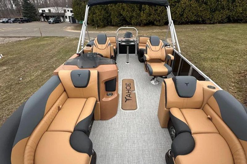 Slide: The Image of Luxurious 2025 Tahoe 2185 pontoon boat with tan and black seating, parked on grass. - 18