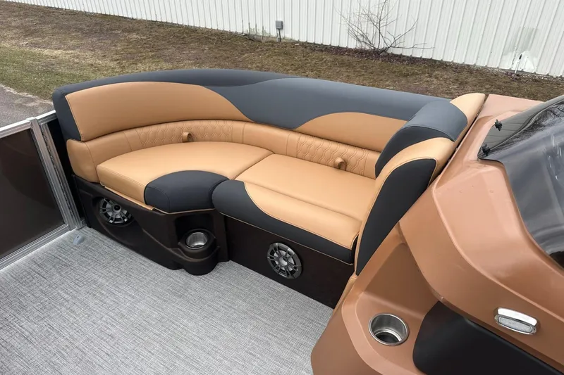 Slide: The Image of Luxurious seating on 2025 Tahoe 2185 boat, featuring tan and black upholstery with cup holders. - 25