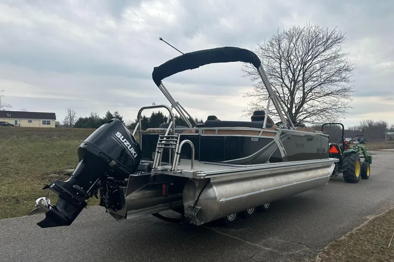 Slide: The Image of 2025 Tahoe 2185 pontoon boat with Suzuki outboard motor on a trailer. - 6