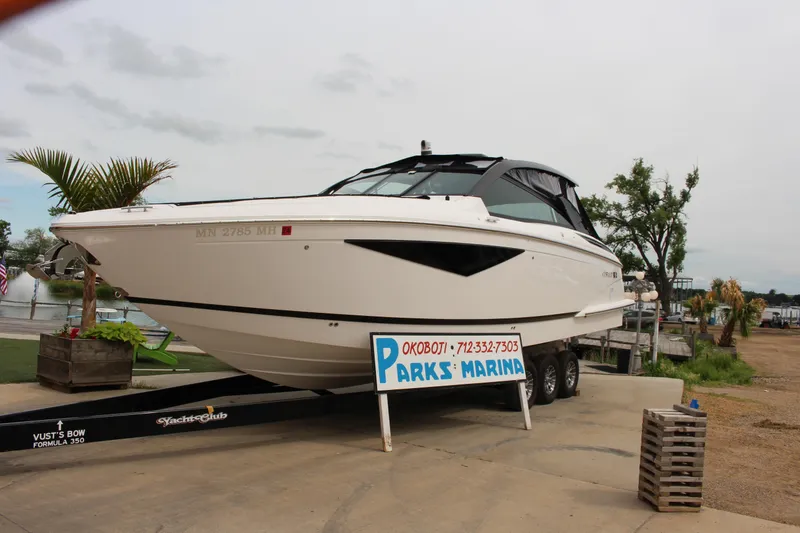 Slide: The Image of 2022 Cobalt A36 boat on trailer at Parks Marina, surrounded by trees and water. - 1