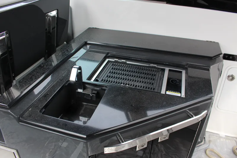 Slide: The Image of 2022 Cobalt A36 boat kitchen with sleek black countertop and built-in grill. - 5