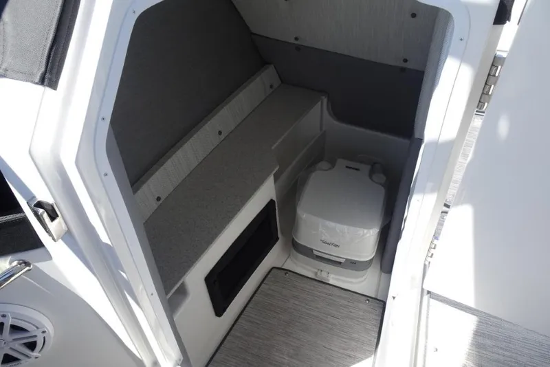 Slide: The Image of Interior of 2026 Cobalt R8 Surf boat featuring compact toilet area. - 17