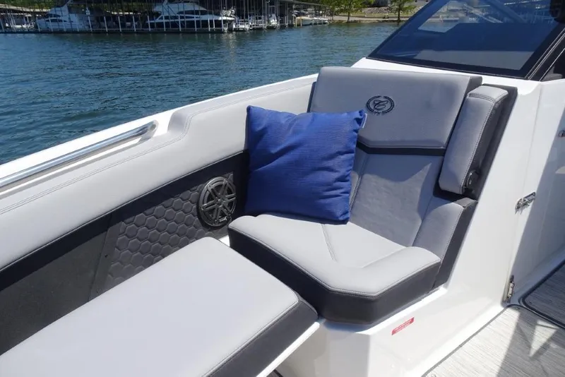 Slide: The Image of Luxurious seating on 2026 Cobalt R8 Surf boat with blue cushion, docked by the water. - 19
