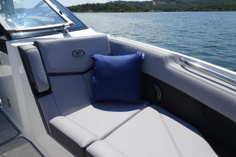 Slide: The Image of Luxurious seating on 2026 Cobalt R8 Surf boat with blue cushion, scenic lake view. - 20