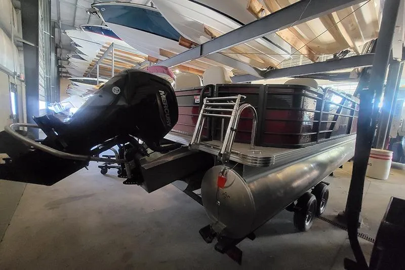 Slide: The Image of 2022 Crest 220 SF pontoon boat in storage with Mercury outboard motor. - 4