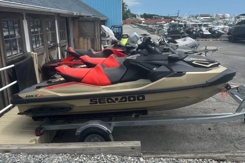 Slide: The Image of 2025 Sea-Doo RXT-X 325 jet ski on trailer, parked at marina. - 3