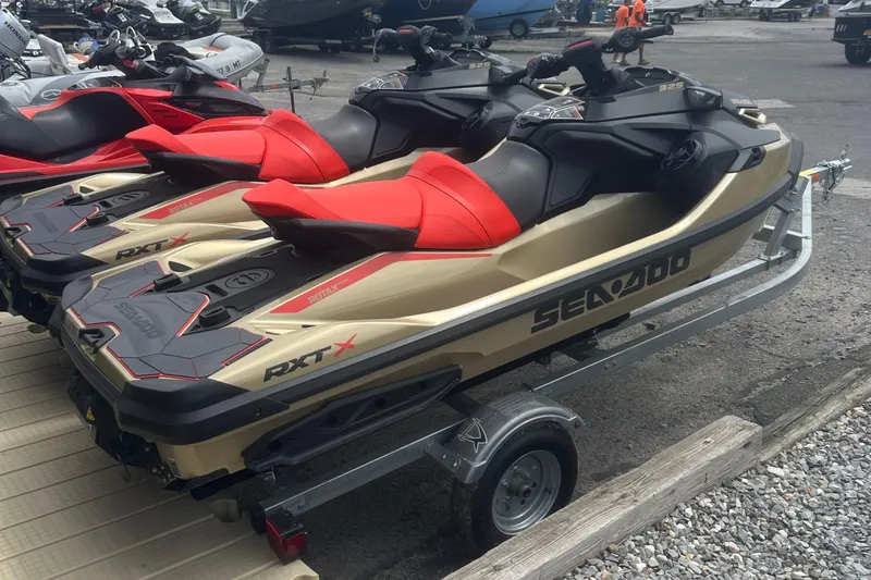 Slide: The Image of 2025 Sea-Doo RXT-X 325 jet skis on trailer, featuring sleek design and vibrant red seats. - 5