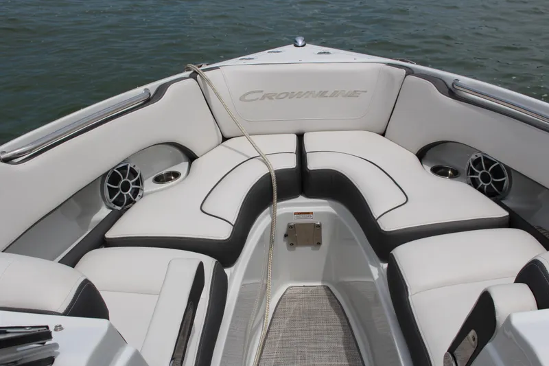 Slide: The Image of 2022 Crownline 240 SS boat interior with white cushioned seating and cup holders. - 11