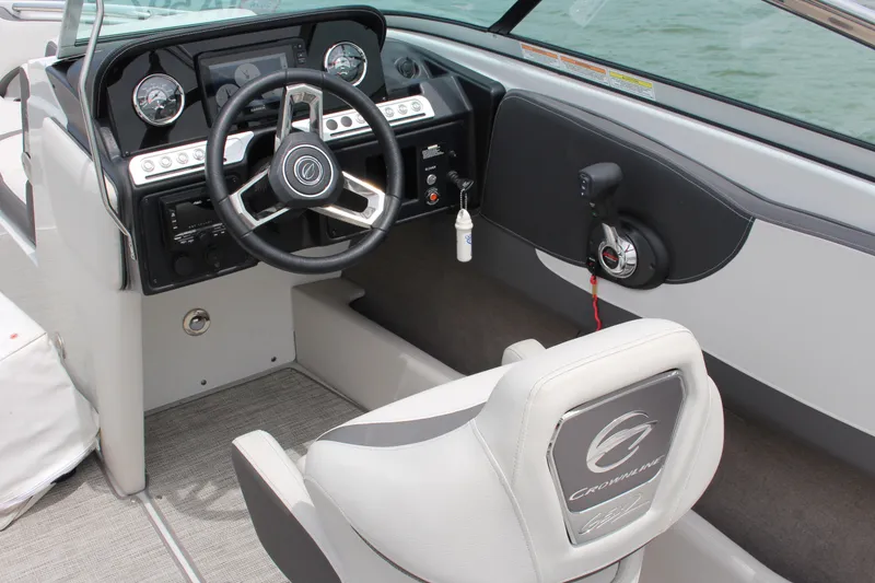 Slide: The Image of 2022 Crownline 240 SS boat interior with steering wheel and dashboard controls. - 3