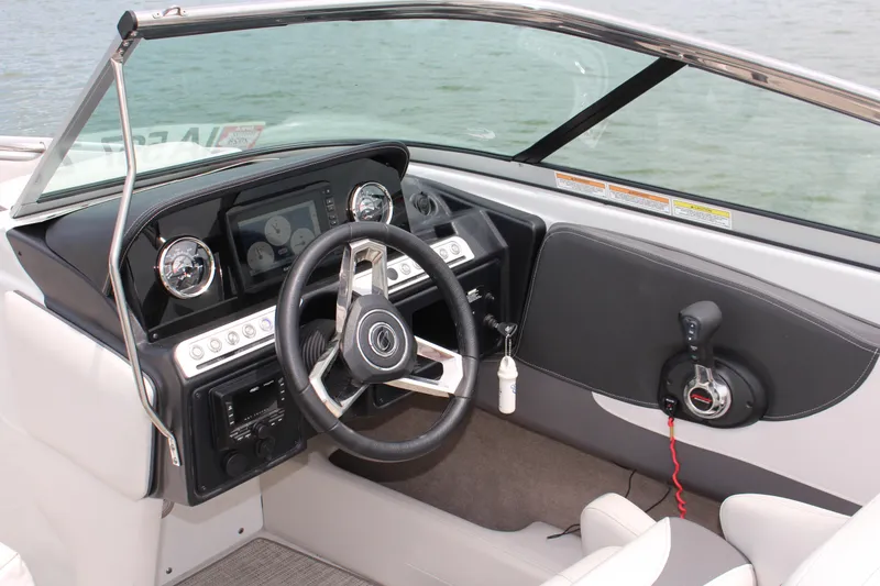 Slide: The Image of 2022 Crownline 240 SS boat dashboard with steering wheel and control panel. - 4
