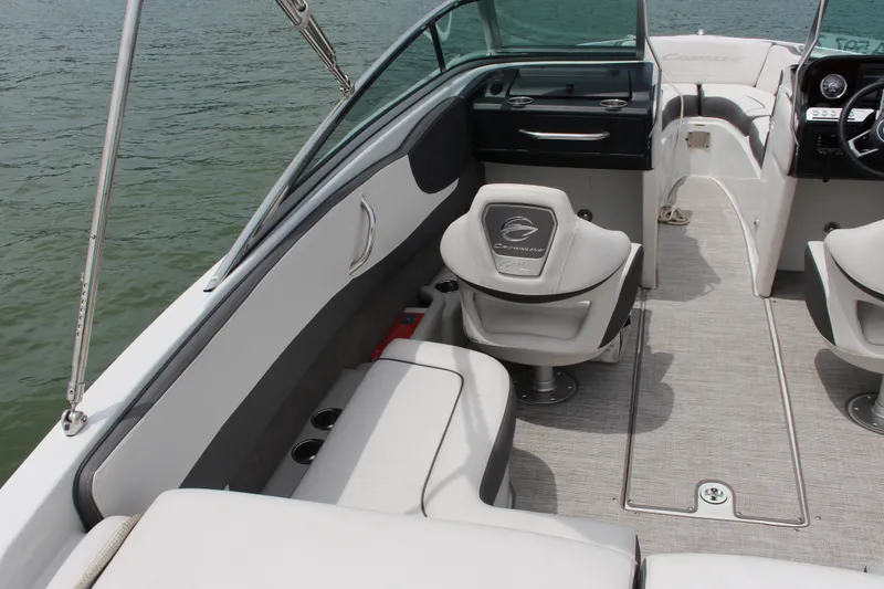 Slide: The Image of 2022 Crownline 240 SS boat interior with seating and dashboard, on calm water. - 5